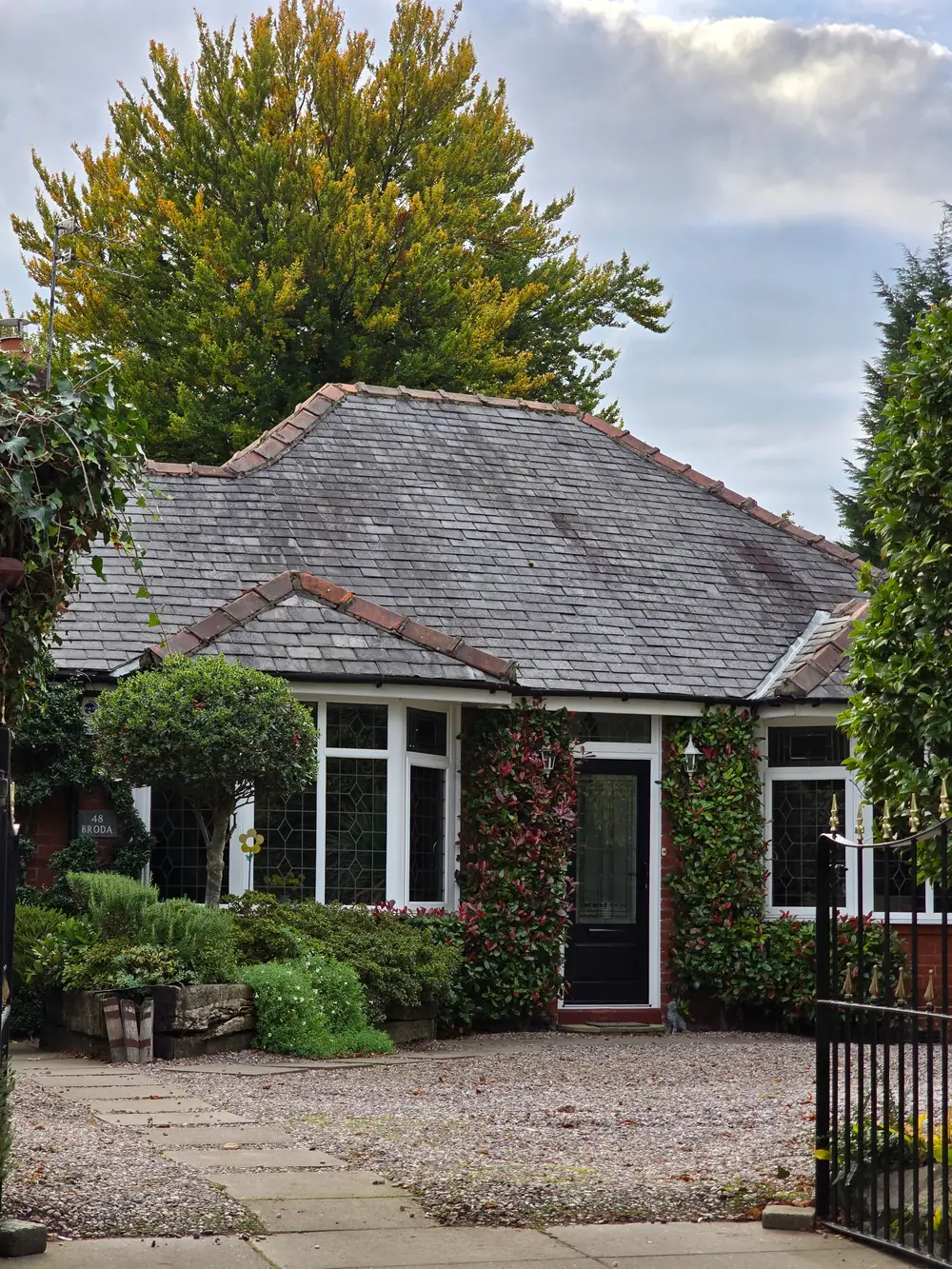 Traditional brick bungalow with a slate roof, landscaped garden and front entrance